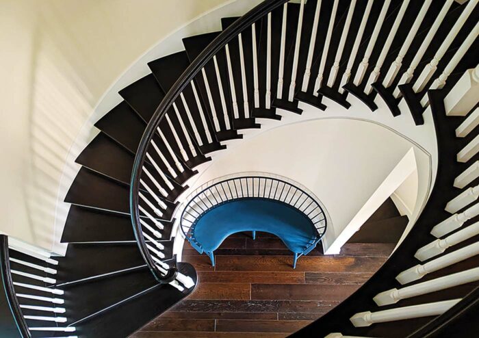 curved blue windsor bench under spiral staircase