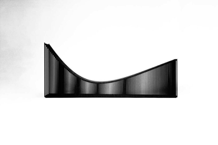 black wood vertical panel sculpture with negative space in-between each panel, by Gunther Pfeffer