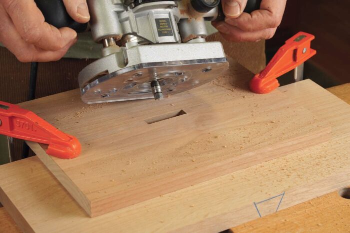 Make a test cut. Clamp the template to some scrap, and rout a mortise. Vacuum out the dust, and make one last pass to be sure to get a full cut. 