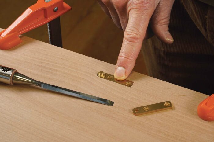 Square one end of the mortise and test the fit. The hinge should end up flush with the surface, without any significant gaps.