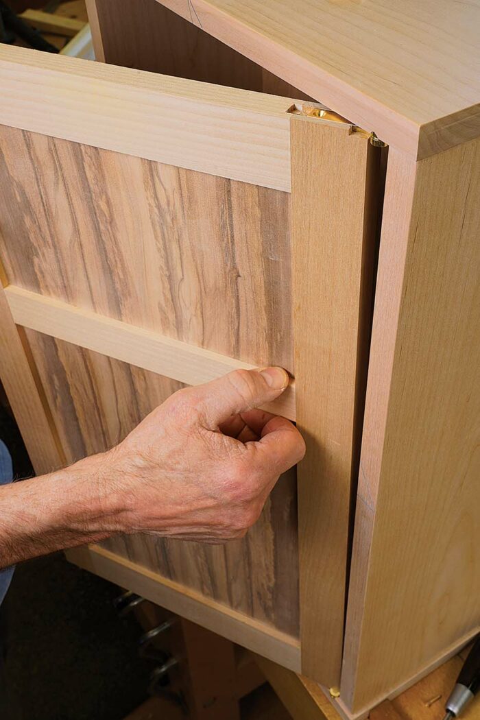 Next, while holding the top door leaf on the pivot pin of the upper case leaf, tilt the door inward to push the top door leaf into its mortise
